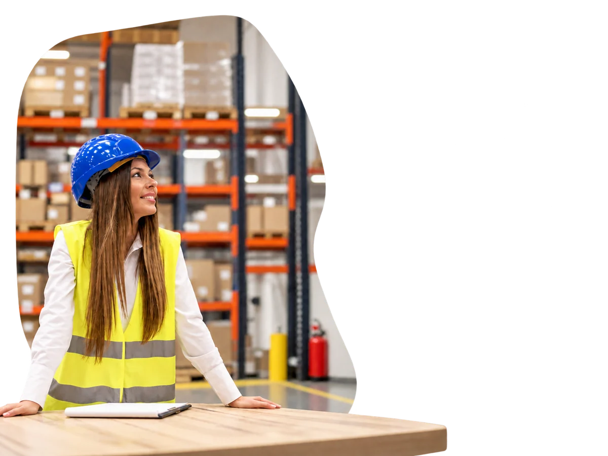 Colaboradora con casco y chaleco reflectante mira una pantalla informativa en su empresa.